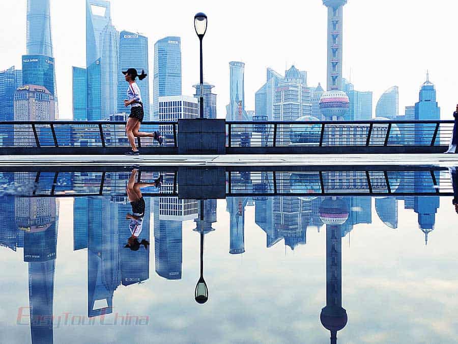 A girl run by Oriental Pearl TV Tower in the morning